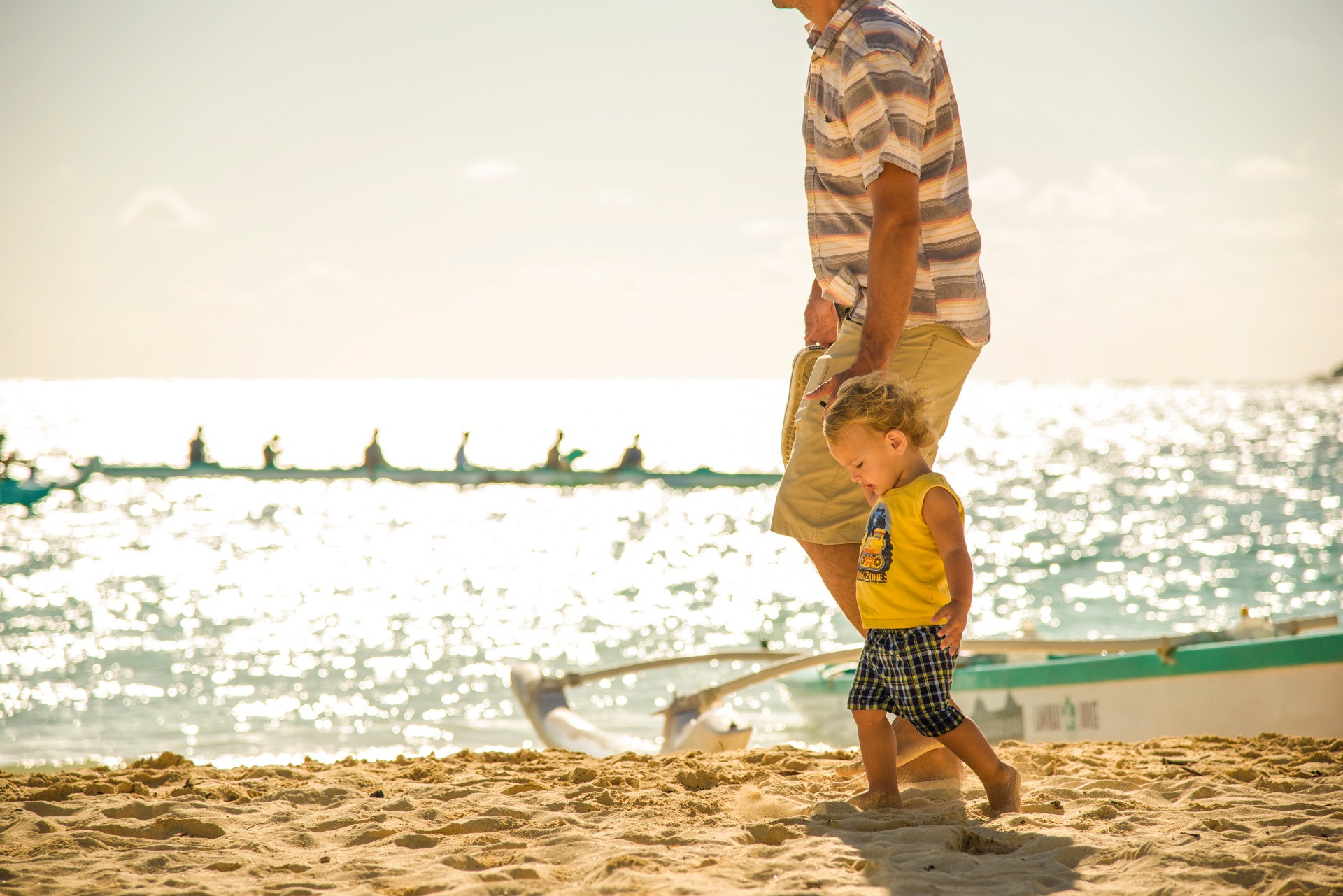 ハワイの海辺を歩く親子